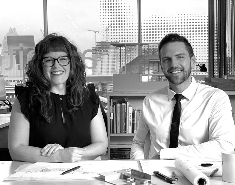 Architects Sarah Johnson and Matt Fajkus sitting at a table with blueprints.